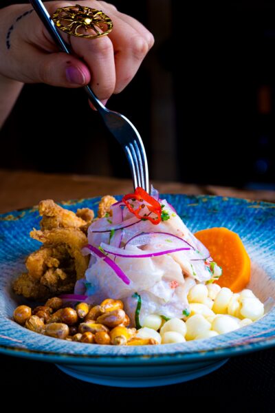 Ceviche peruano clássico de peixe branco servido com cebola roxa, milho chulpi frito, milh