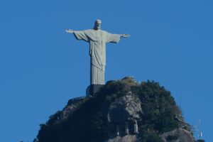 Cristo Redentor no topo do morro do Corcovado sob um céu azul claro.