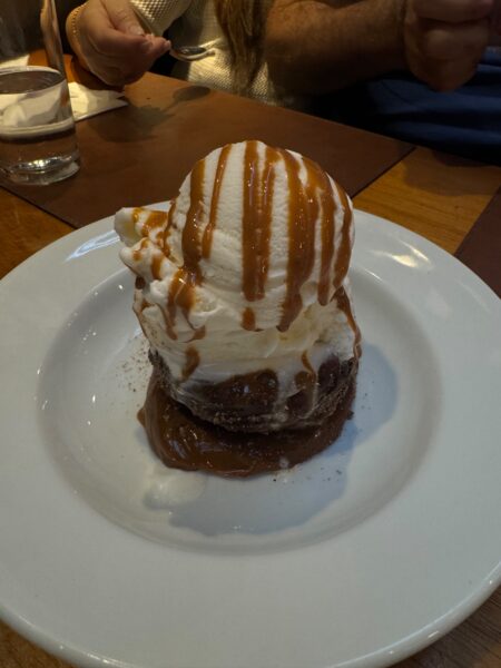 Sobremesa do restaurante Fuego Celeste composta por um bolinho quente com base de doce de leite, uma bola grande de sorvete de creme e calda de caramelo por cima.
